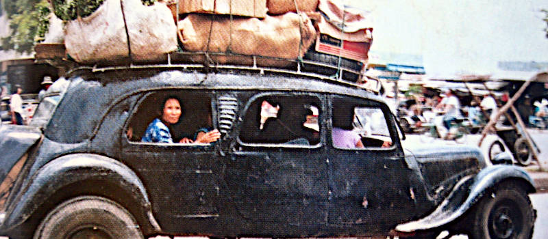 thème airsoft - opération Dien Bien Phu ne répond plus - vieille voiture française surchargée, au Vietnam et quitant un marché